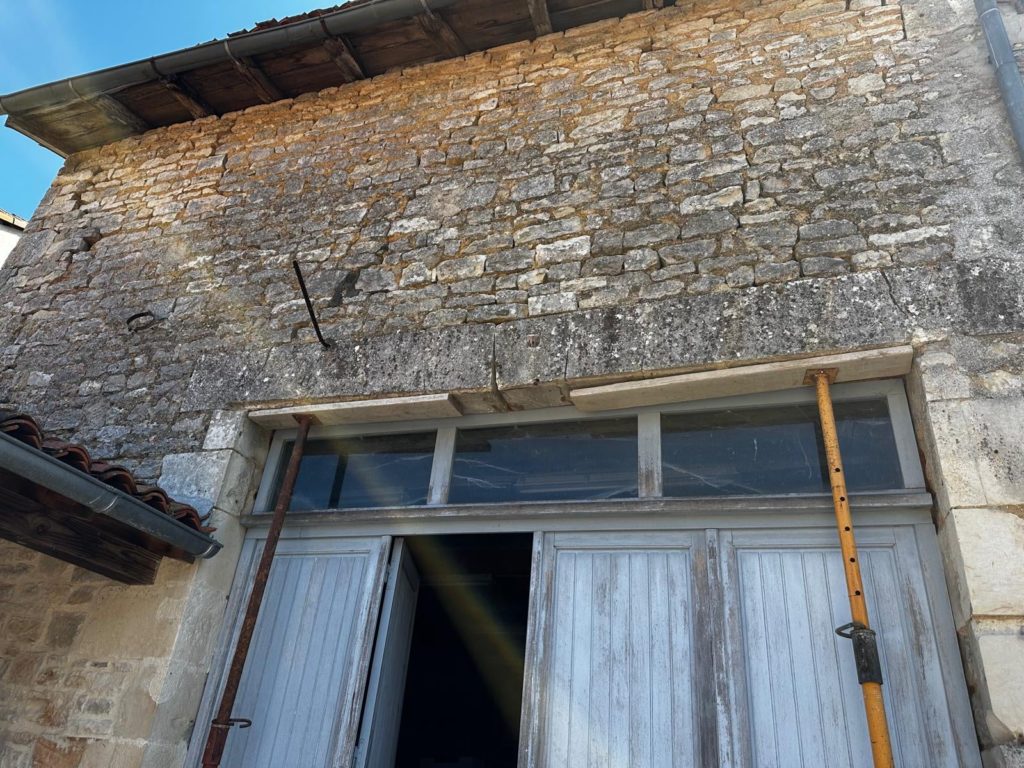 Ancien linteau fissuré étayé au-dessus d'une porte de grange avant travaux, Angoulême