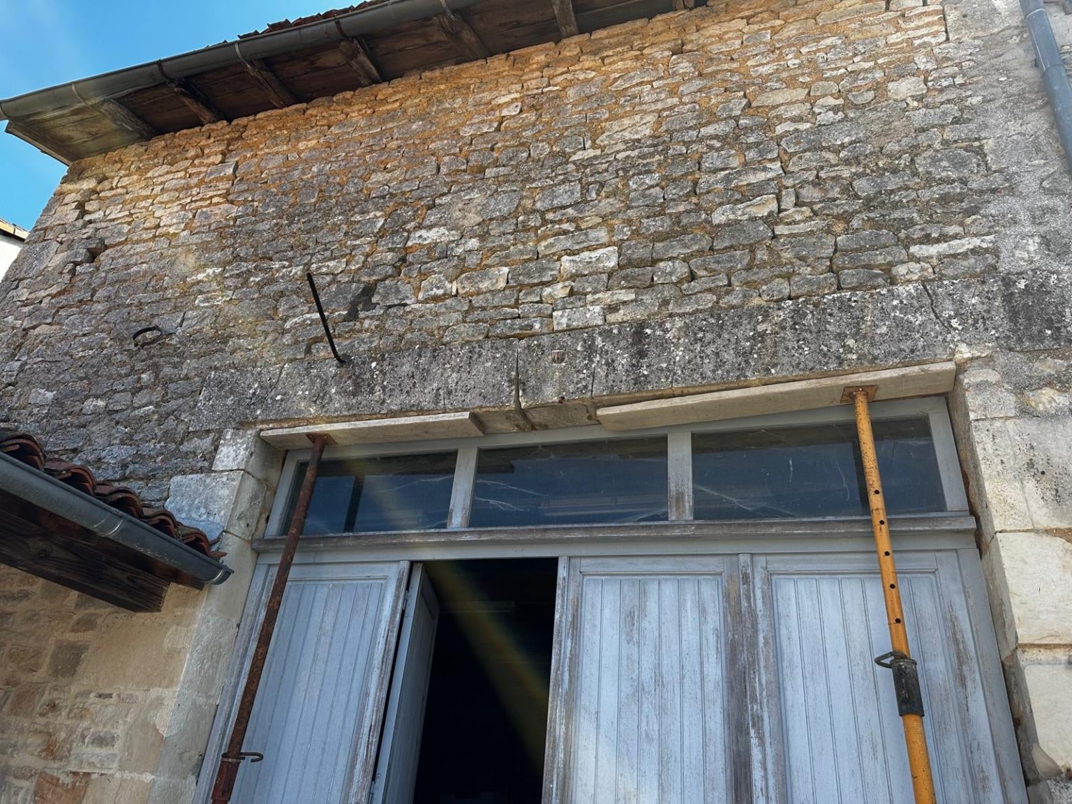 Ancien linteau fissuré étayé au-dessus d'une porte de grange avant travaux, Angoulême