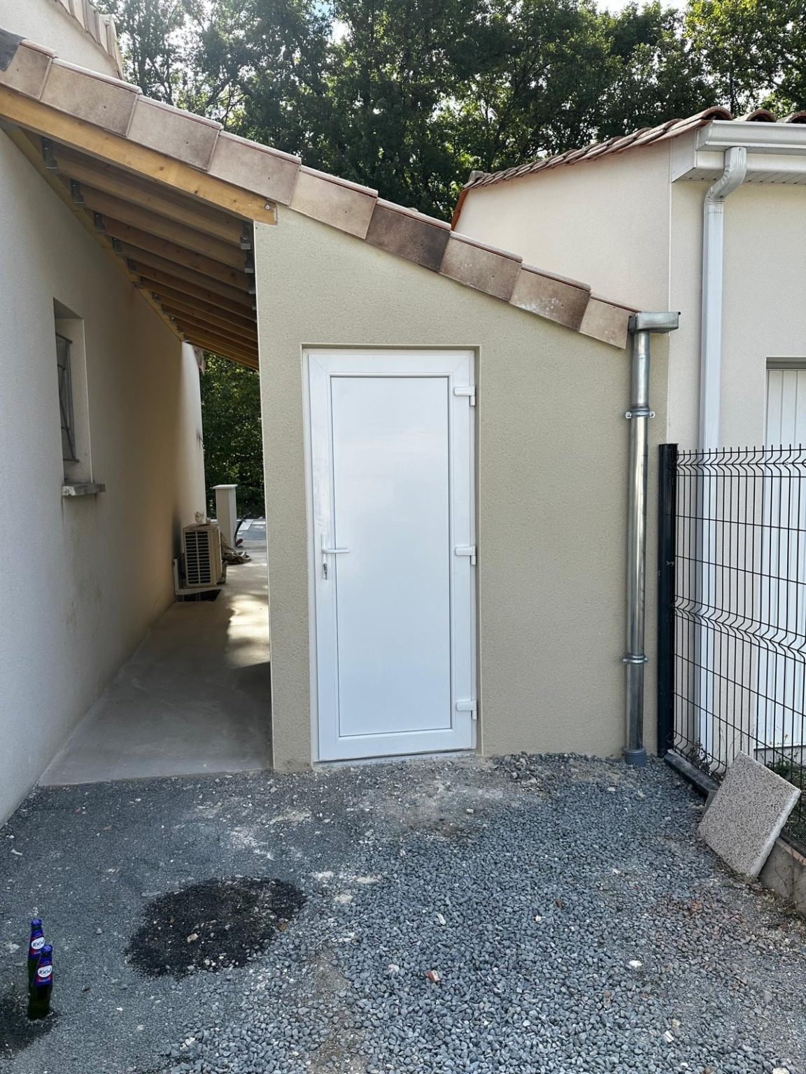 Garage enduit avec porte de service, prolongé par le préau en charpente bois, Nersac