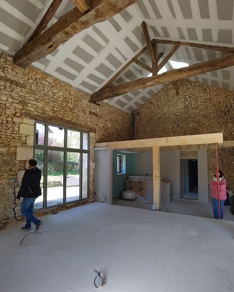Grande pièce sous charpente avec baie vitrée, maison en pierre à Terres-de-Haute-Charente
