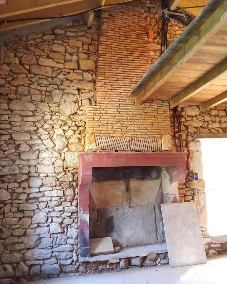 Cheminée et mur en pierre apparente remis à nu, Terres-de-Haute-Charente