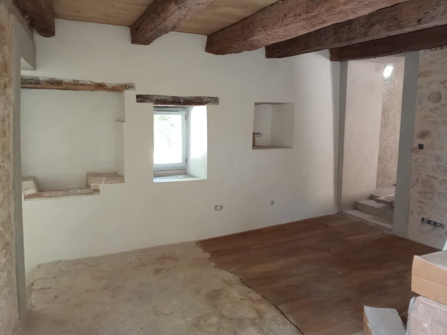 Pièce à vivre rénovée avec poutres apparentes, maison en pierre à Terres-de-Haute-Charente