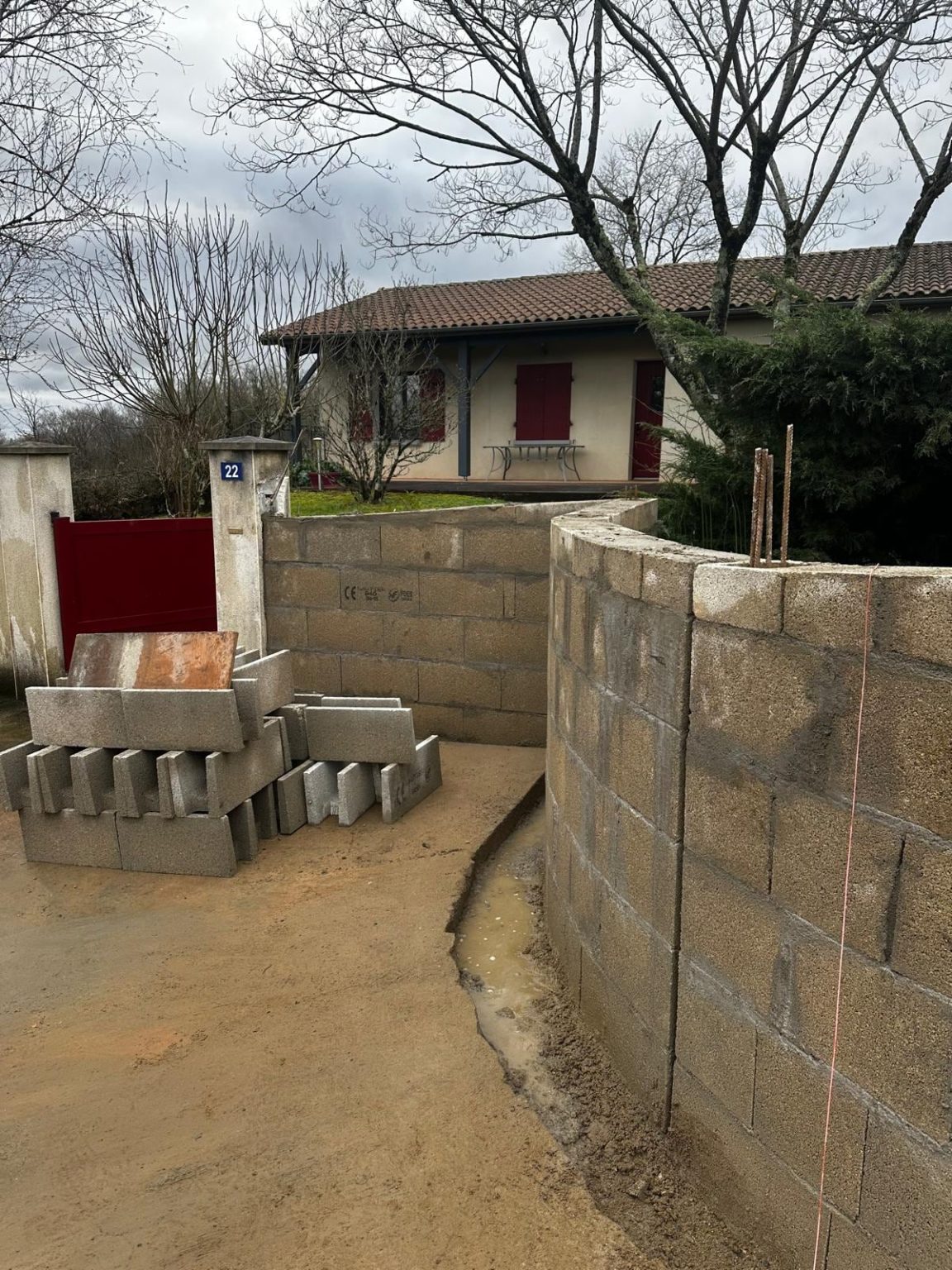 Mur de clôture courbe en blocs béton près du pilier, Ruffec