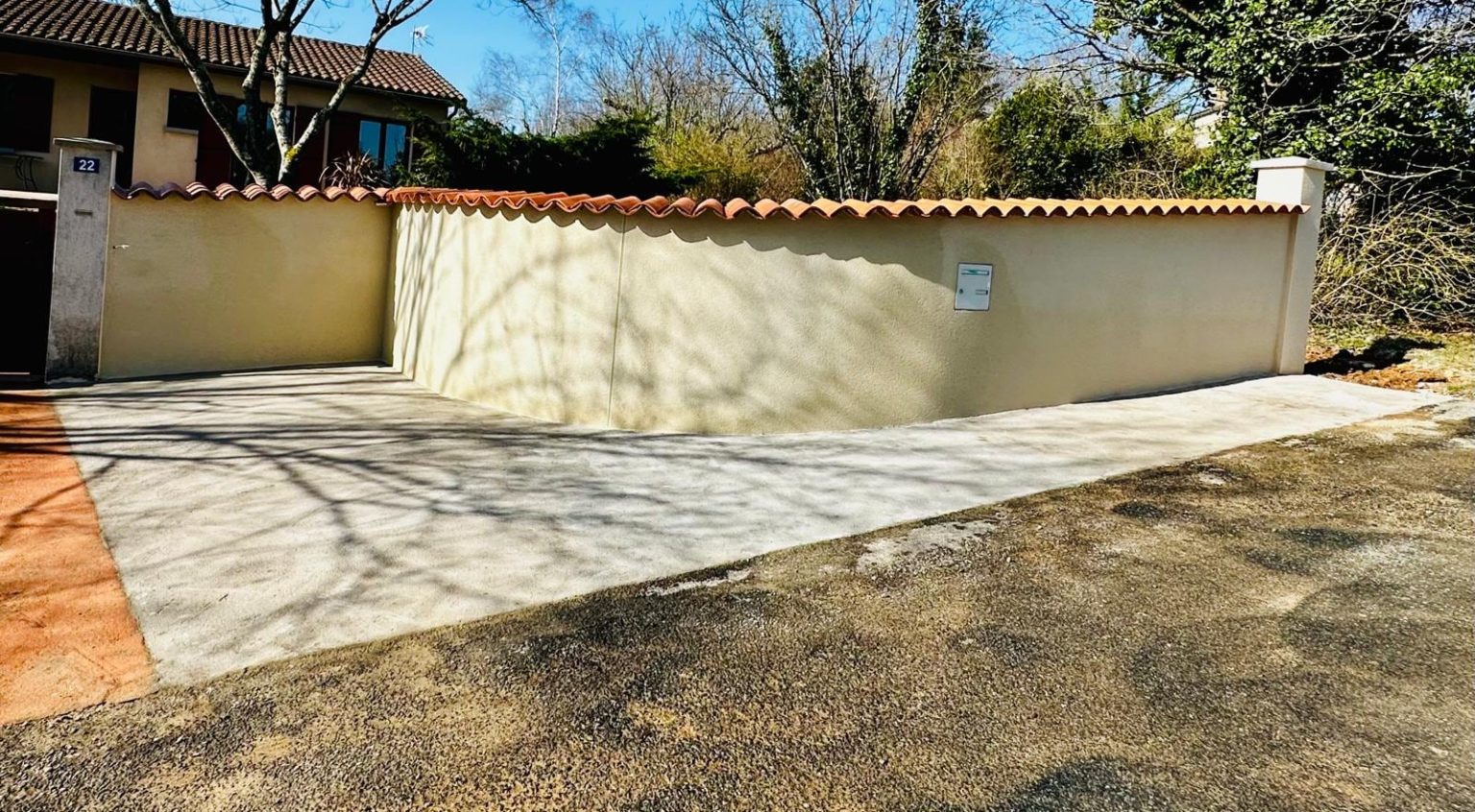 Mur de clôture enduit et allée en béton, Ruffec