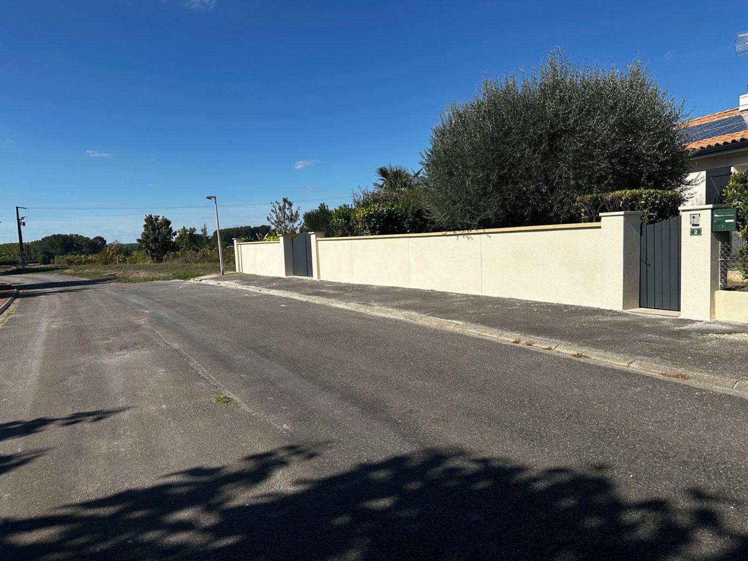 Mur de clôture enduit le long de la route, Saint-Maurice-des-Lions