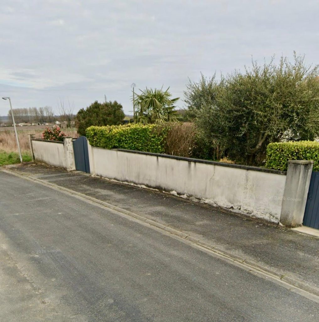 Mur de clôture enduit en bordure de rue, Saint-Maurice-des-Lions
