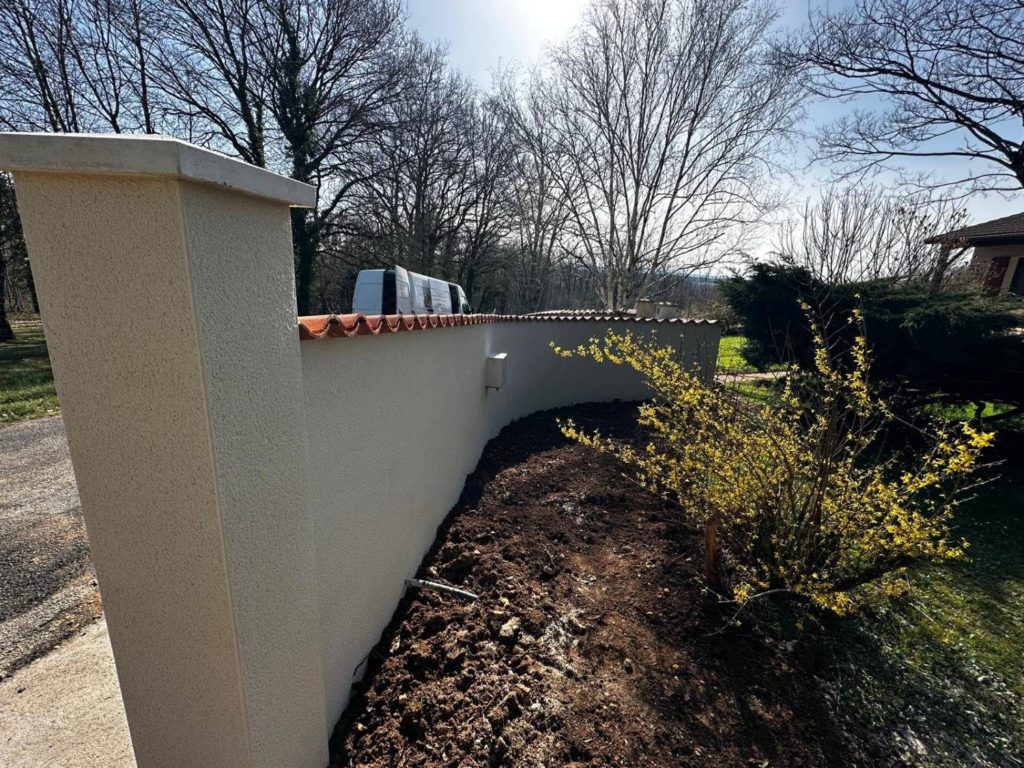 Mur de clôture courbe et pilier enduits à Ruffec