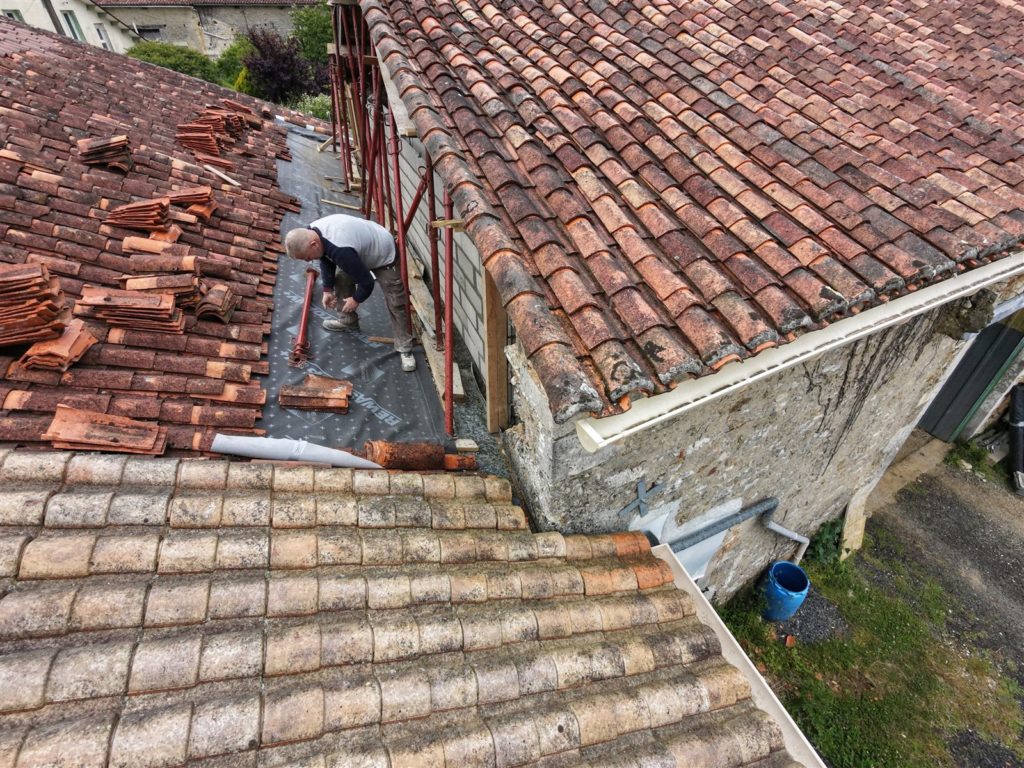 Couvreur posant l’écran sous toiture sur la grange, Verteuil-sur-Charente