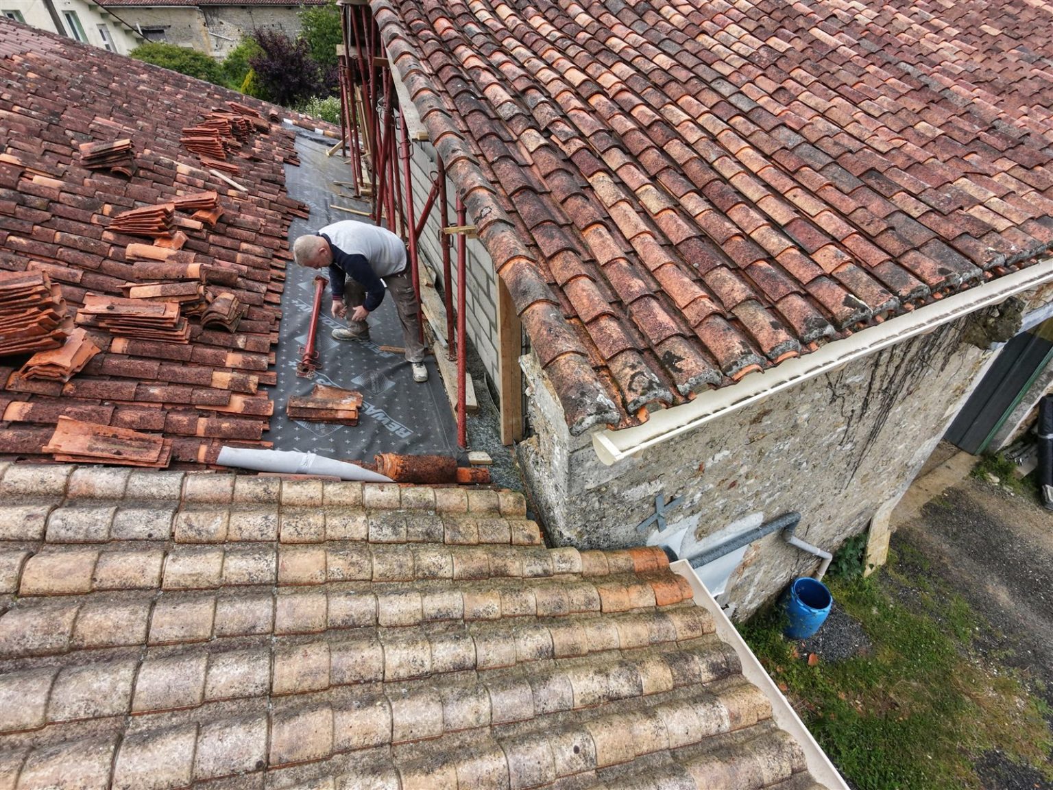 Couvreur posant l’écran sous toiture sur la grange, Verteuil-sur-Charente